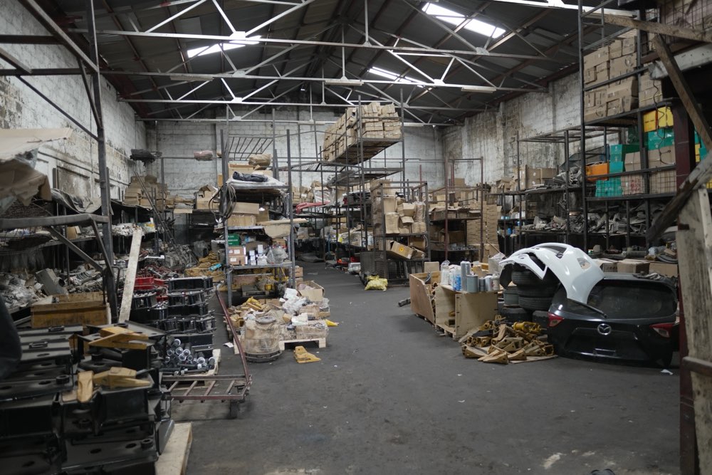 The main floor of the Ajale Enterprises warehouse, stacked with heavy machinery parts